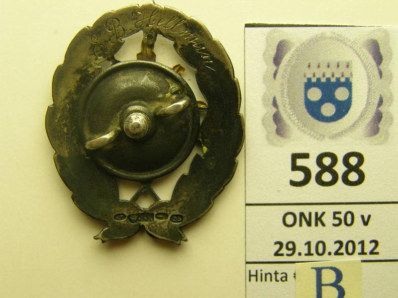 k-0588-b.jpg - Kohde 588 (kuva 2/2), lhthinta: 75 € Ag, Kadettikunnan merkki, vanha malli, miekat alas. Kntp. omistuskaiverrus EB Hellman, hopean leimat, kunto: 8